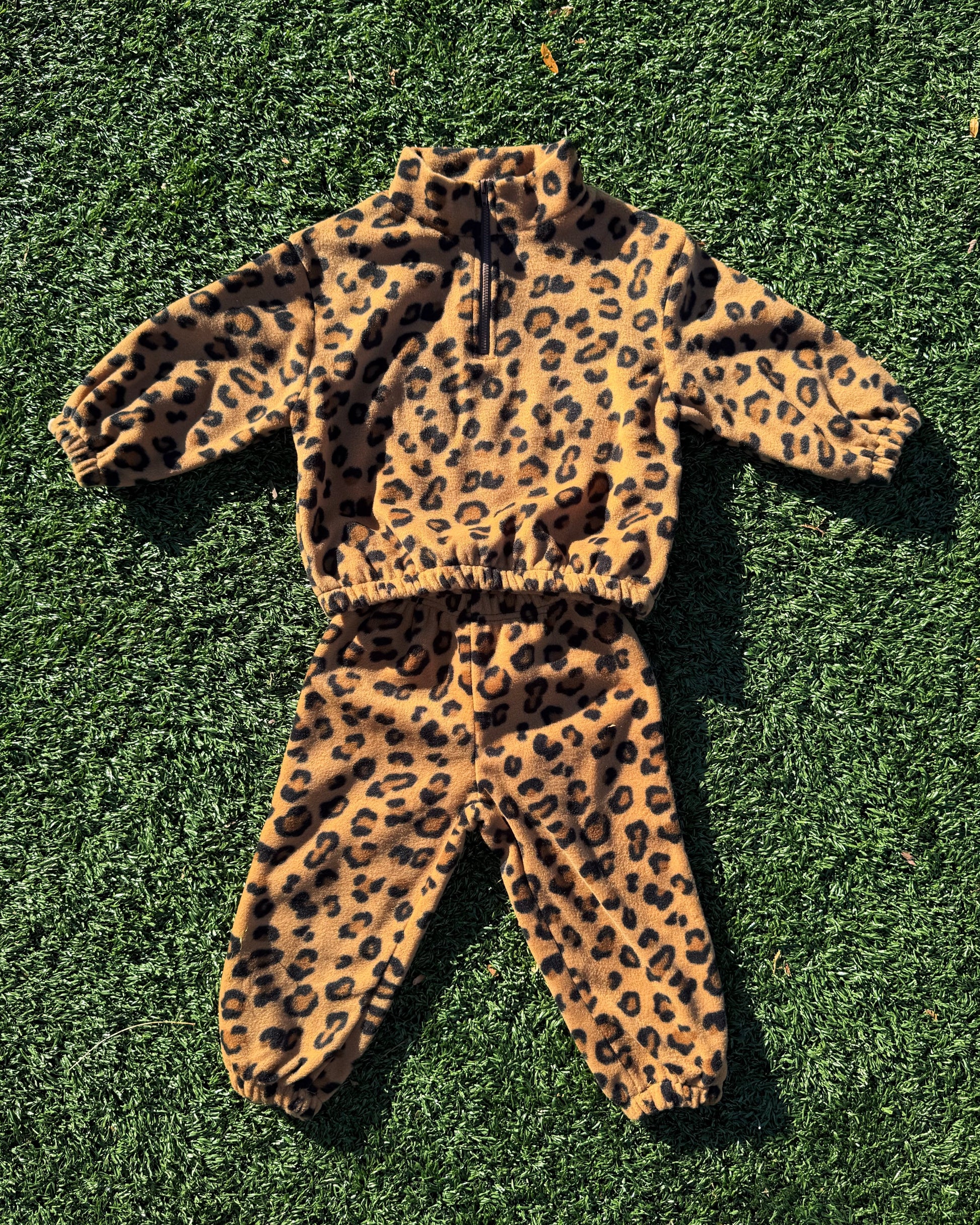 Leopard print toddler outfit on a green grass background