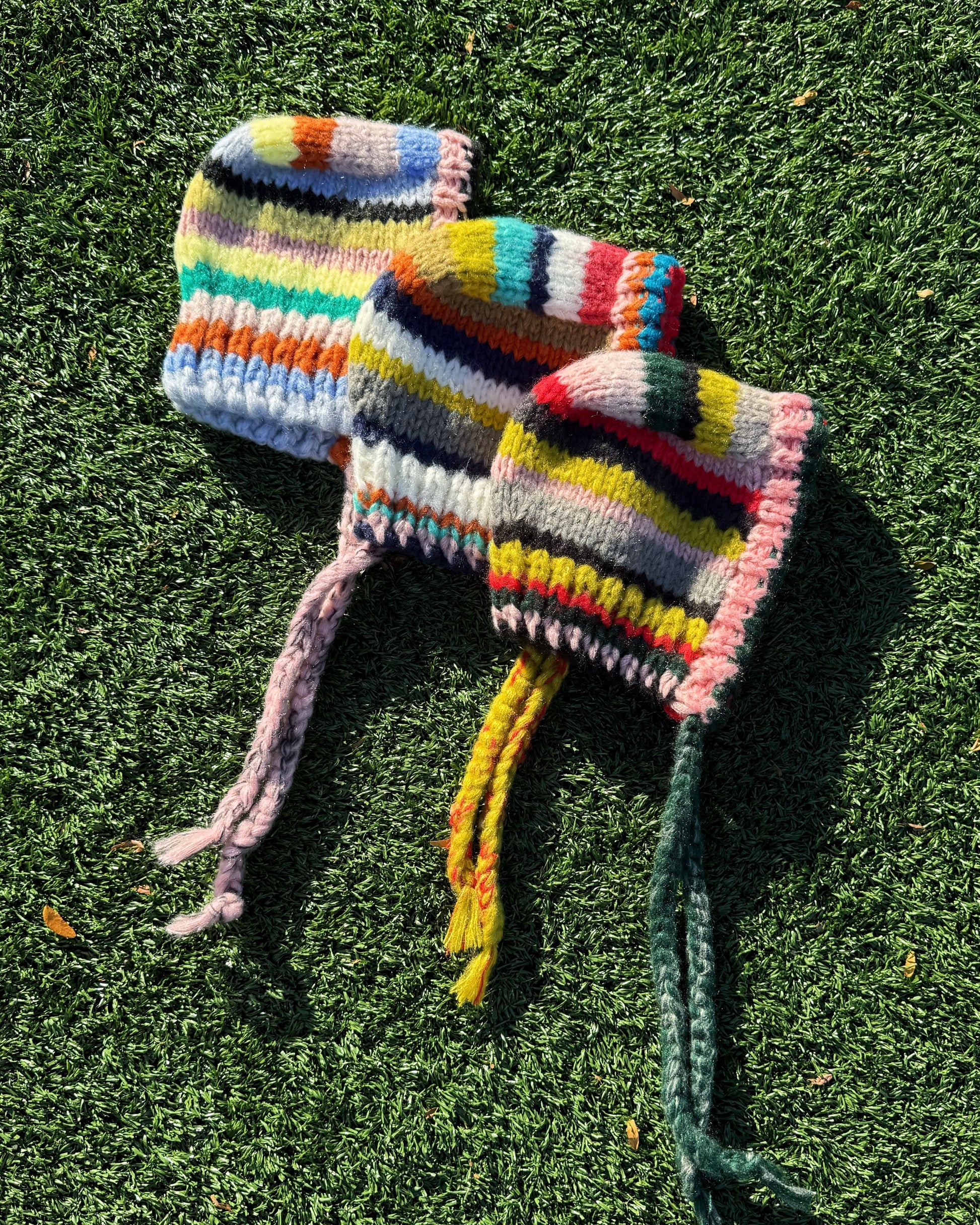 Colorful knitted hats on grass