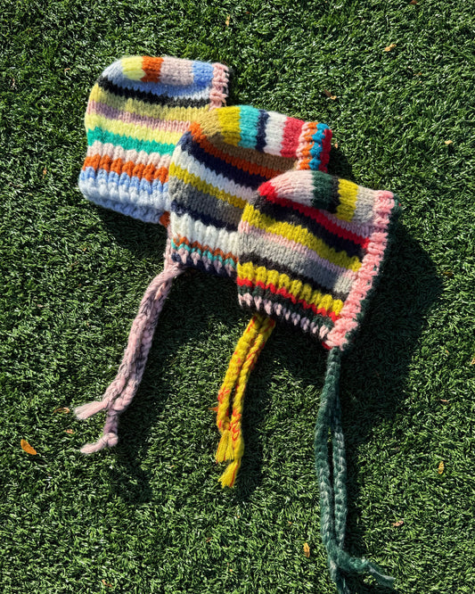 Colorful knitted hats on grass